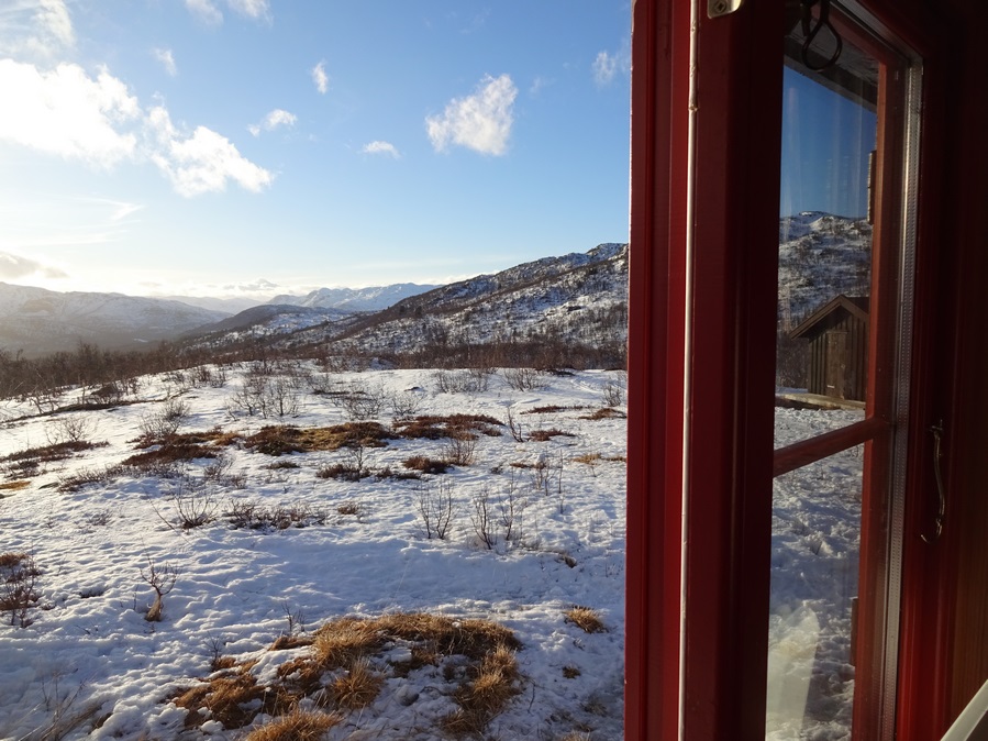 Uitzicht op sneeuwlandschap en bergen vanuit hut tijdens huttentocht in Noorwegen