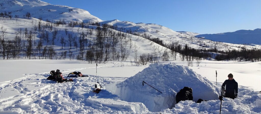 Bouwen van een quinzee of sneeuwhut in winters Noorwegen.