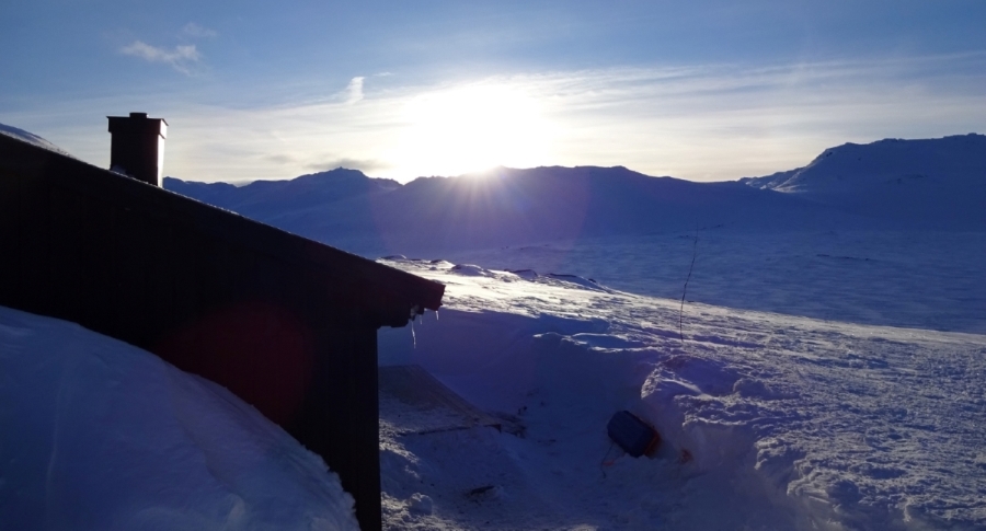 Berghut in Noorwegen in de winter bij zonsondergang.
