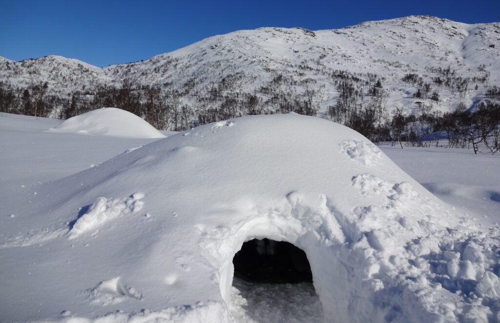 Een quinzee of sneeuwhut bouwen bij wintersurvival.