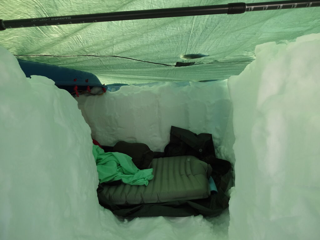 Een noodbivak met een tarp in de sneeuw als overlevingstechniek