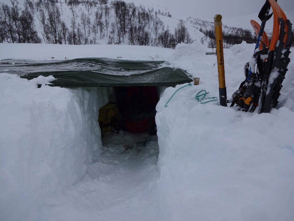 Bij de wintersurvival maak je een noodbivak van je tarp